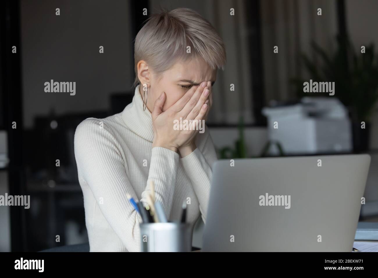 Tosse di un dipendente femminile malsano sul posto di lavoro Foto Stock