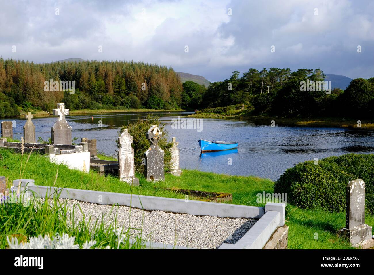 Scorcio di un cimitero irlandese che si affaccia su un lago. Sono visibili le caratteristiche croci celtiche. Foto Stock