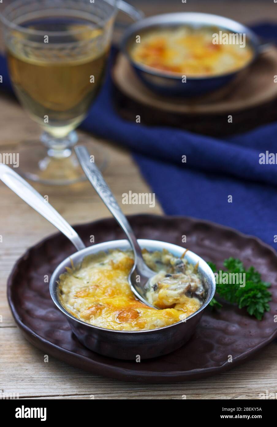 Julienne con funghi e salsa di bechamel con formaggio, servito con vino bianco. Stile rustico. Foto Stock