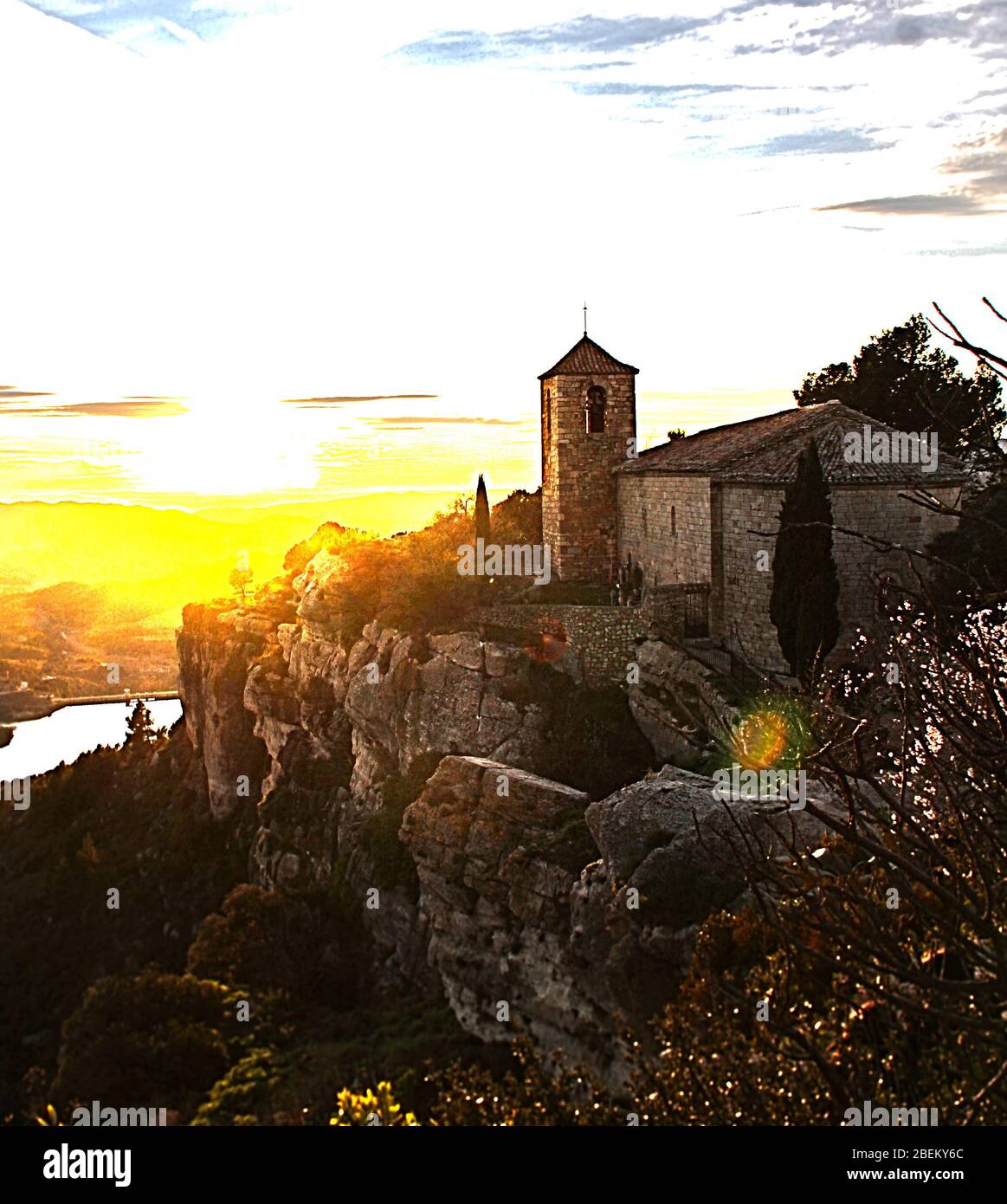 Chiesa spagnola con un fiume al tramonto Foto Stock