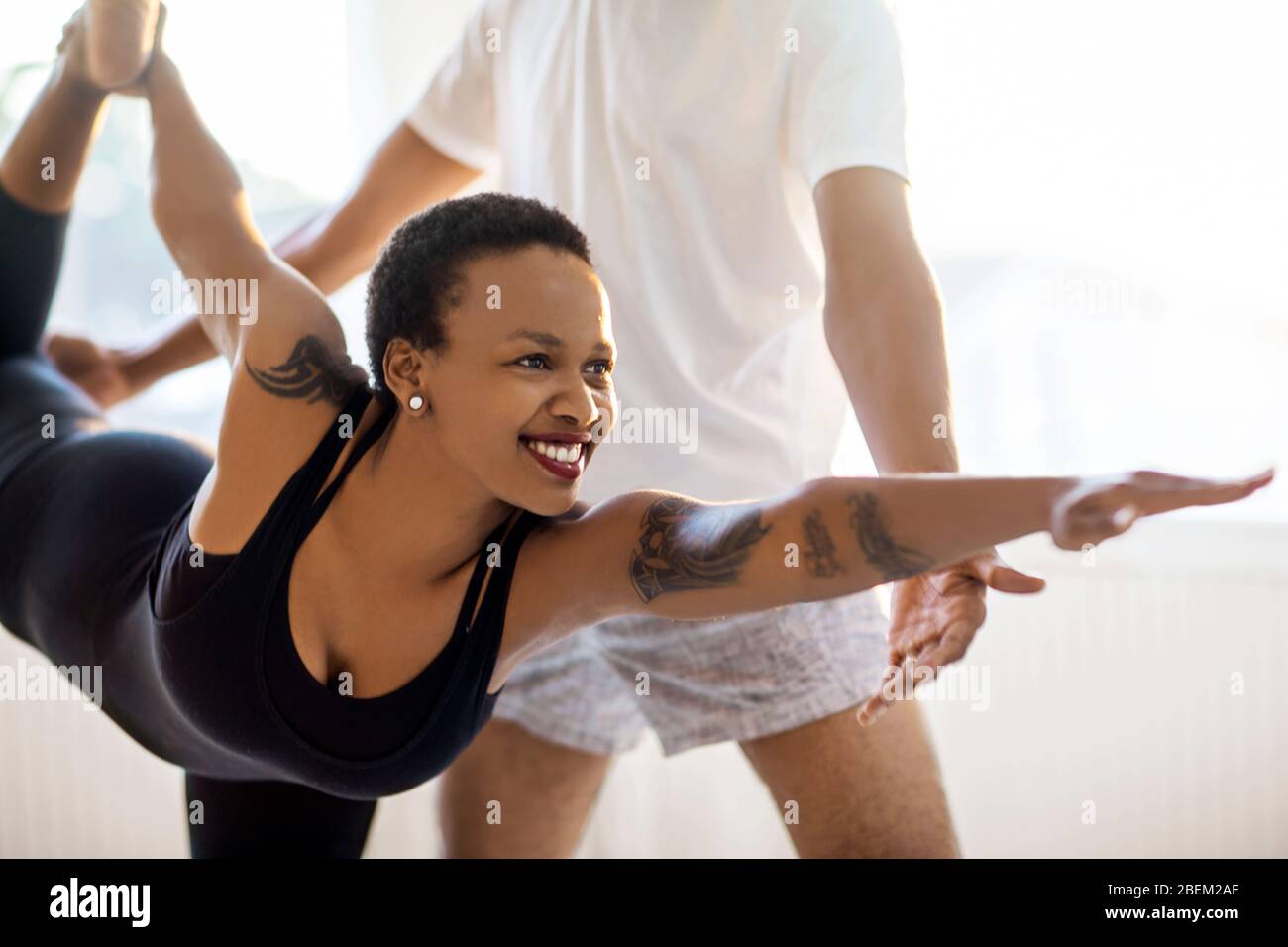 Donna che pratica yoga con un istruttore Foto Stock