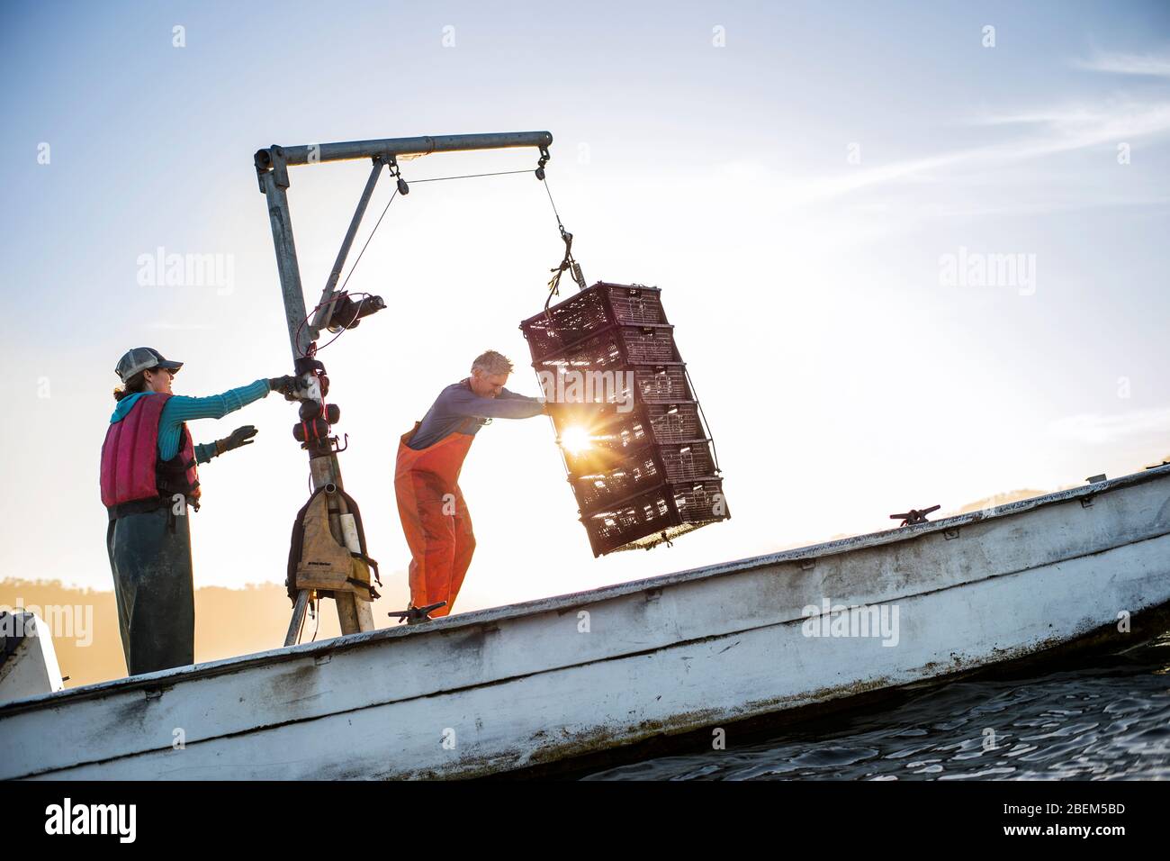 Famiglia di ostriche agricoltori al lavoro sulla loro barca da pesca Foto Stock