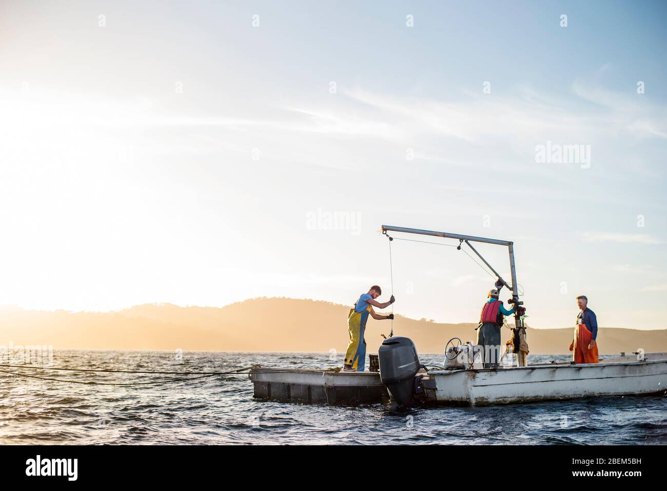 Famiglia di ostriche agricoltori al lavoro sulla loro barca da pesca Foto Stock