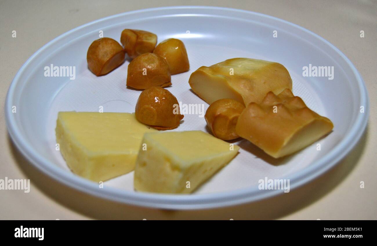 Assortimento di formaggi polacchi su un piatto bianco: Tilsit o Tylżycki, Gołka o Gouka e Oscypek a fette e pronti per una degustazione di formaggi. Smokey che Foto Stock