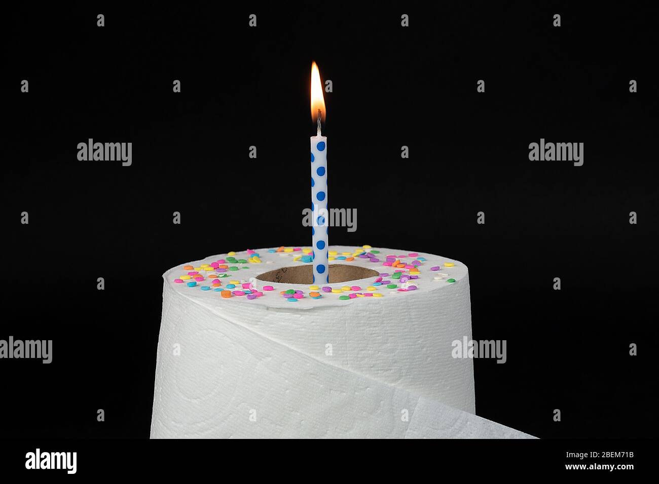 candela di compleanno blu con pallino in rotolo di carta igienica con confetti di caramelle, isolata su nero Foto Stock