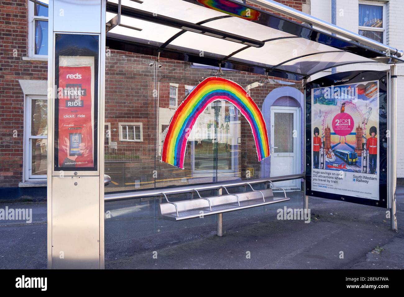 Grande arcobaleno dipinto a mano di colore brillante sul retro di un riparo per autobus durante l'emergenza del virus Corona Foto Stock