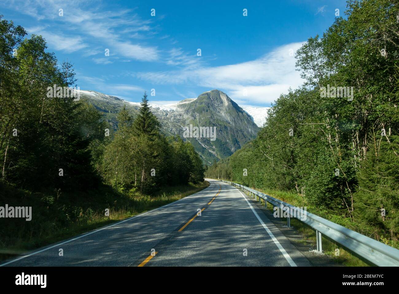 Strada di montagna con il ghiacciaio Josteldalsbreen sullo sfondo, Norvegia Foto Stock