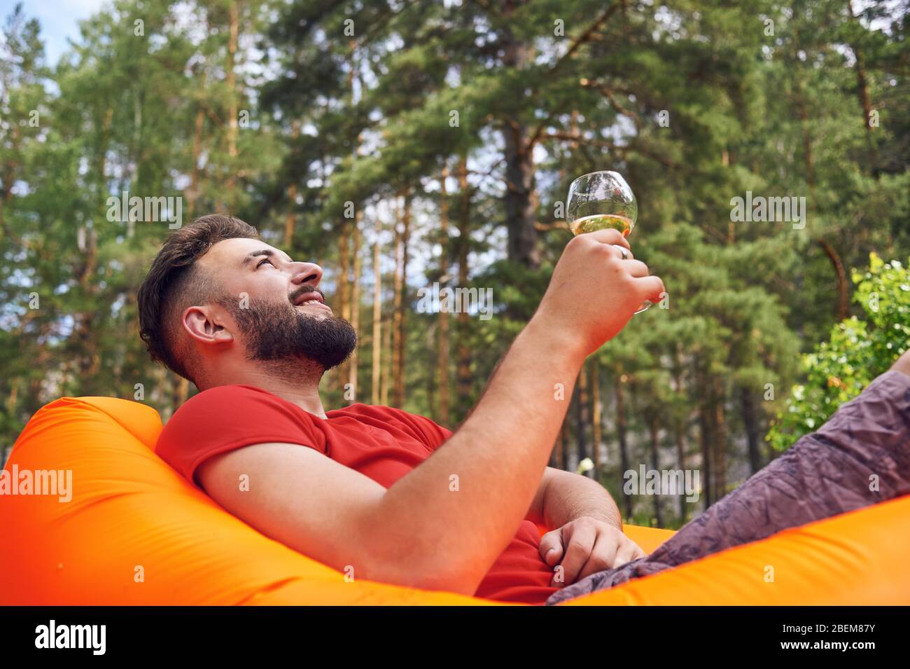 Godersi la vita. Un giovane uomo si trova in un bivacco nella foresta., relax, vacanze, stile di vita concetto Foto Stock