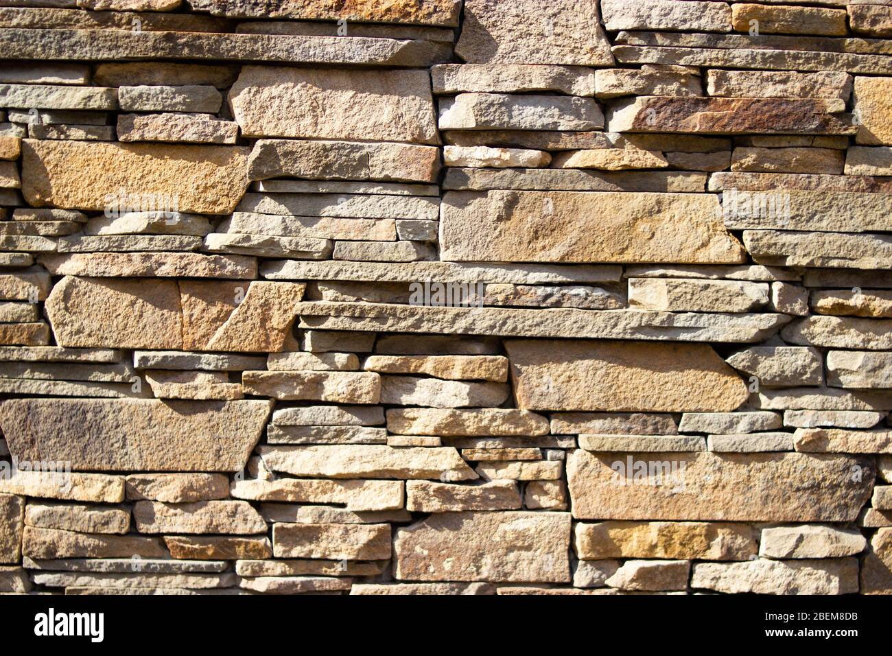 Un muro di mattoni di pietra giallo Foto Stock