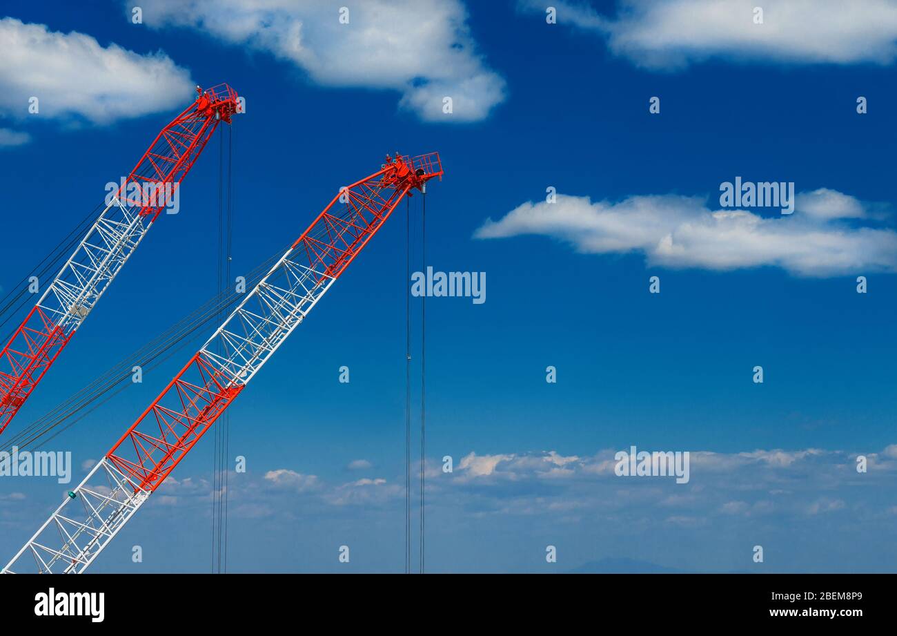 Industria edile e sviluppo. Due gru al lavoro tra le nuvole (con spazio copia) Foto Stock