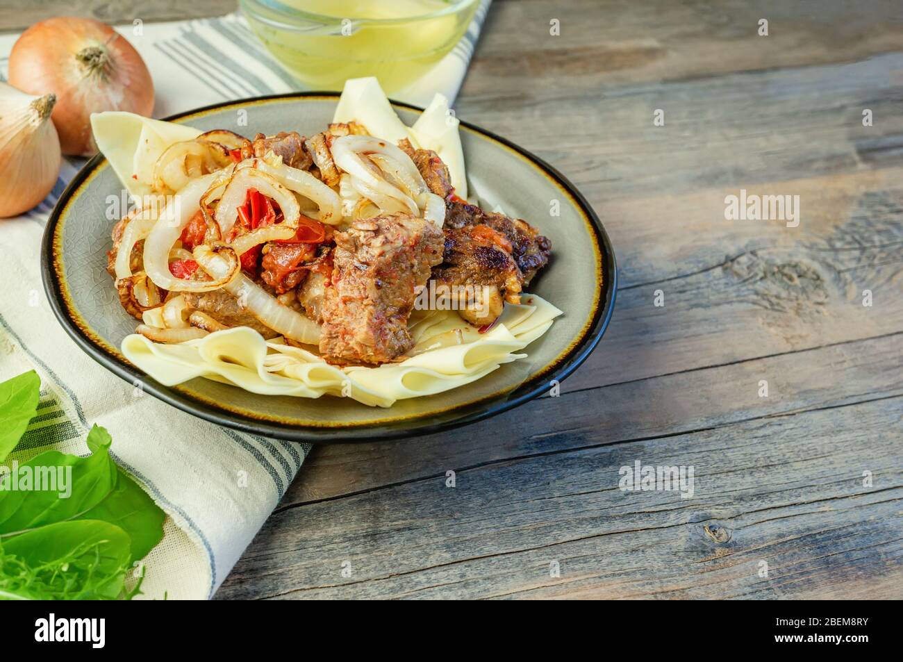 Piatto di Beshbarak: Tagliatelle con agnello e cipolla primo piano su un piatto sul tavolo. Spazio di copia Foto Stock