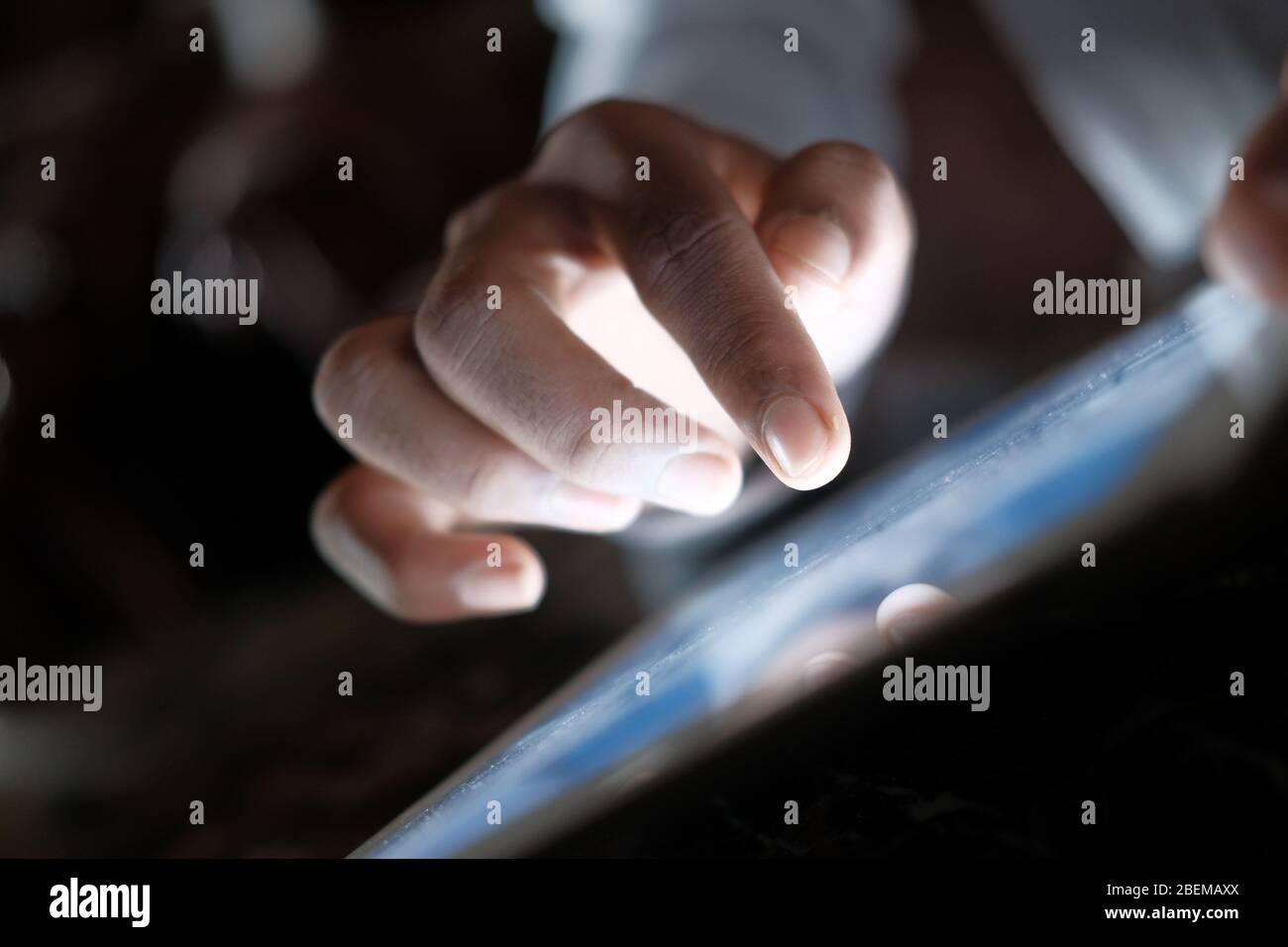 Primo piano della mano dell'uomo con un tablet digitale di notte. Foto Stock