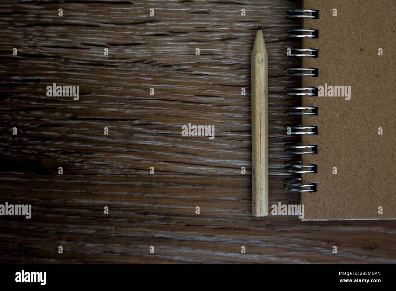 Un vecchio piano da scrivania con un libro di note e una matita per prendere appunti e scrittura creativa con spazio per le copie Foto Stock