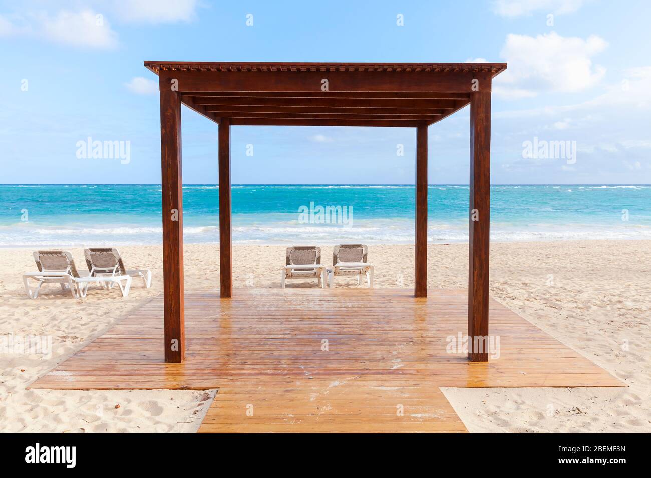 Il gazebo in legno vuoto e i lettini prendisole sono sulla spiaggia di  sabbia durante il giorno di sole, Repubblica Dominicana Foto stock - Alamy