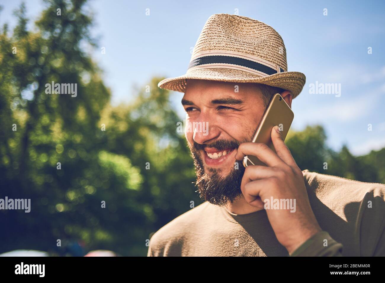 Giovane uomo bearded con uno smartphone su uno sfondo di natura Foto Stock