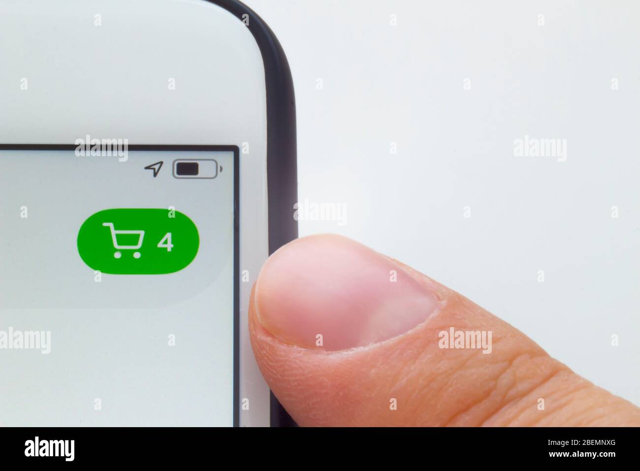 Una persona che sta per guardare un carrello su un telefono e sfondo bianco. Foto Stock