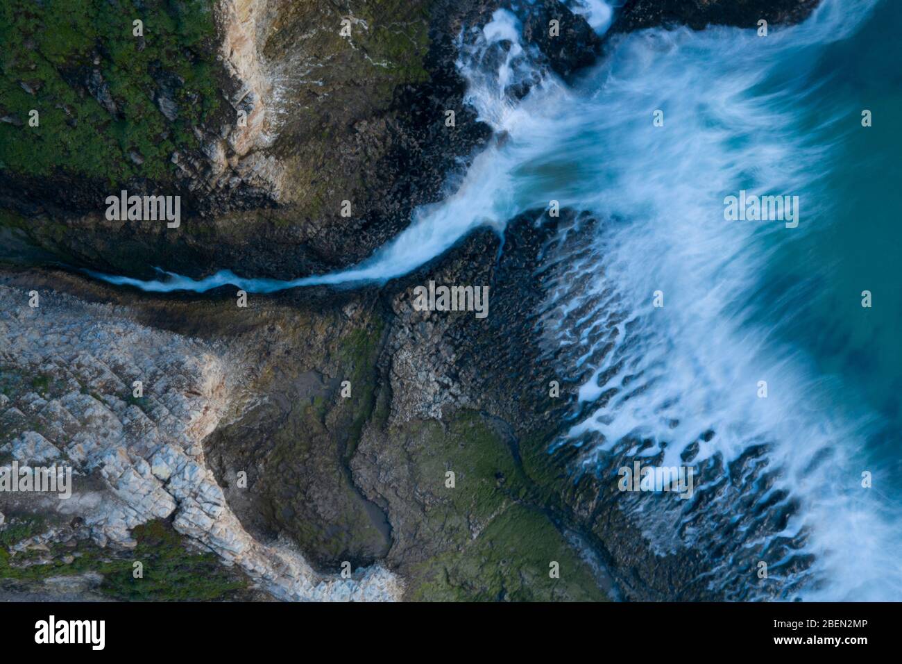 Un ruscello incontra le onde d'onda in una costa di Rockey California Foto Stock