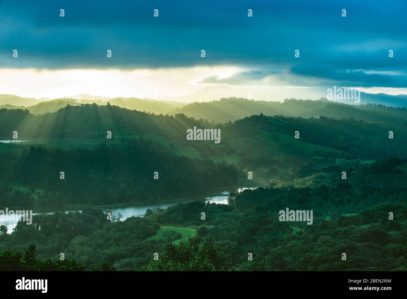 Una brillante Alba diffonde luce raggio attraverso Green Mountain Vista Foto Stock