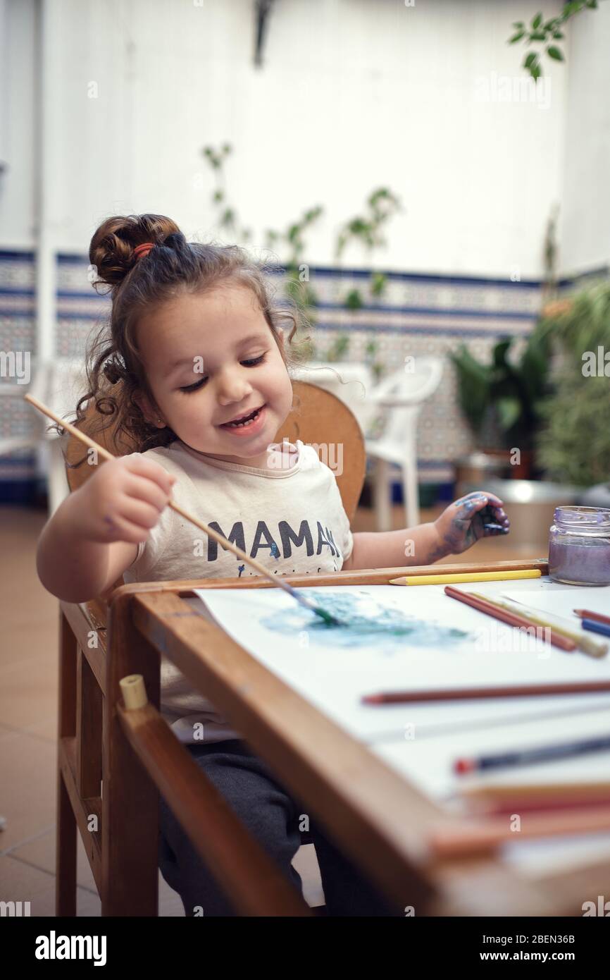 bambini che giocano in un cortile interno e dipingono con vernici ad acqua Foto Stock