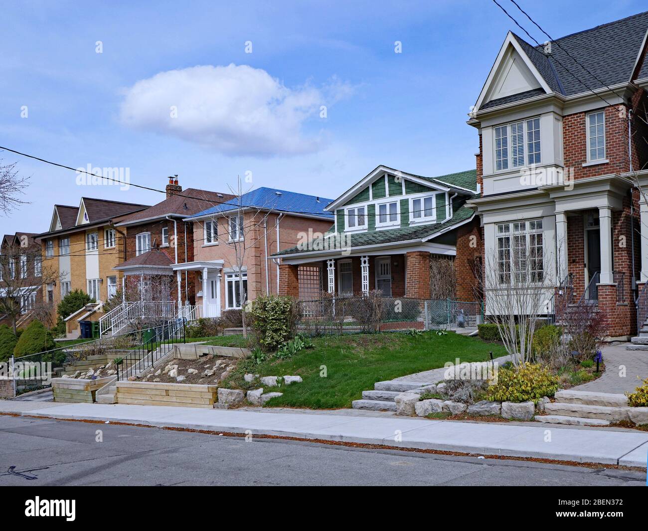 Strada residenziale con una varietà di case più vecchie e più nuove e un mix di distaccati e semi-indipendenti Foto Stock