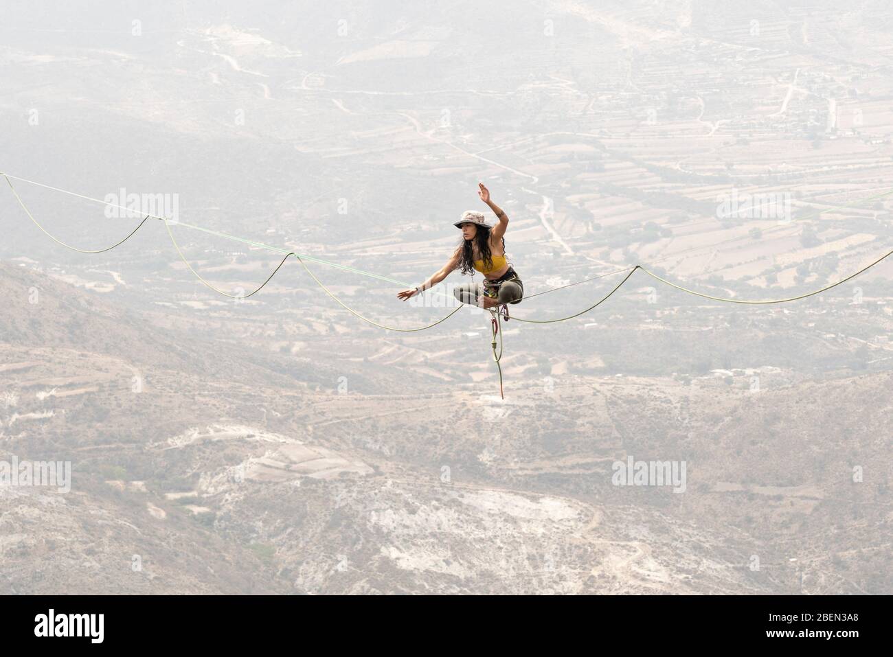 Una ragazza che si bilancia con una posizione yoga in una Highline a Los Frailes Foto Stock