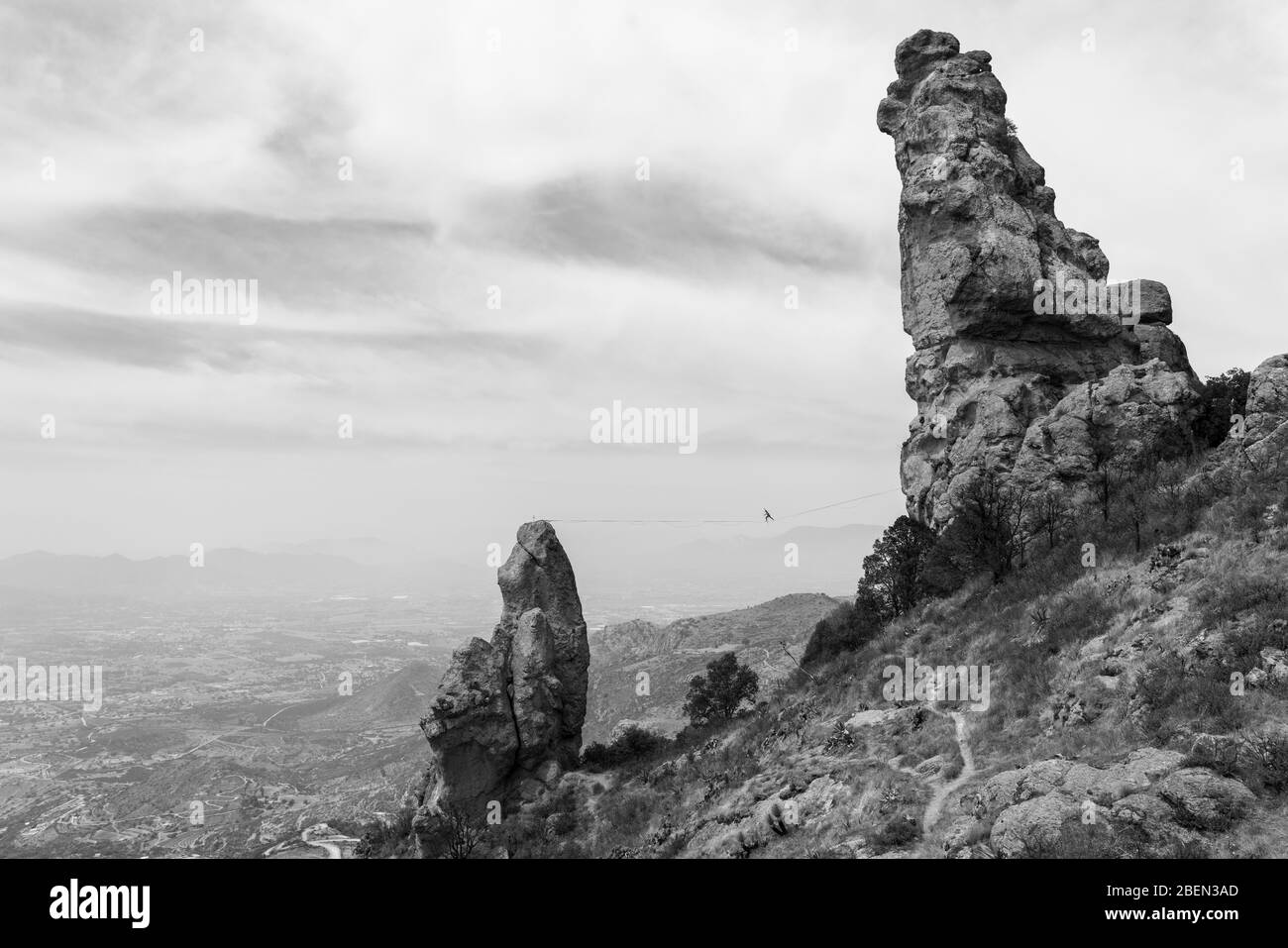 Una persona pone il bilanciamento nel mezzo di una linea alta a Los Frailes Foto Stock