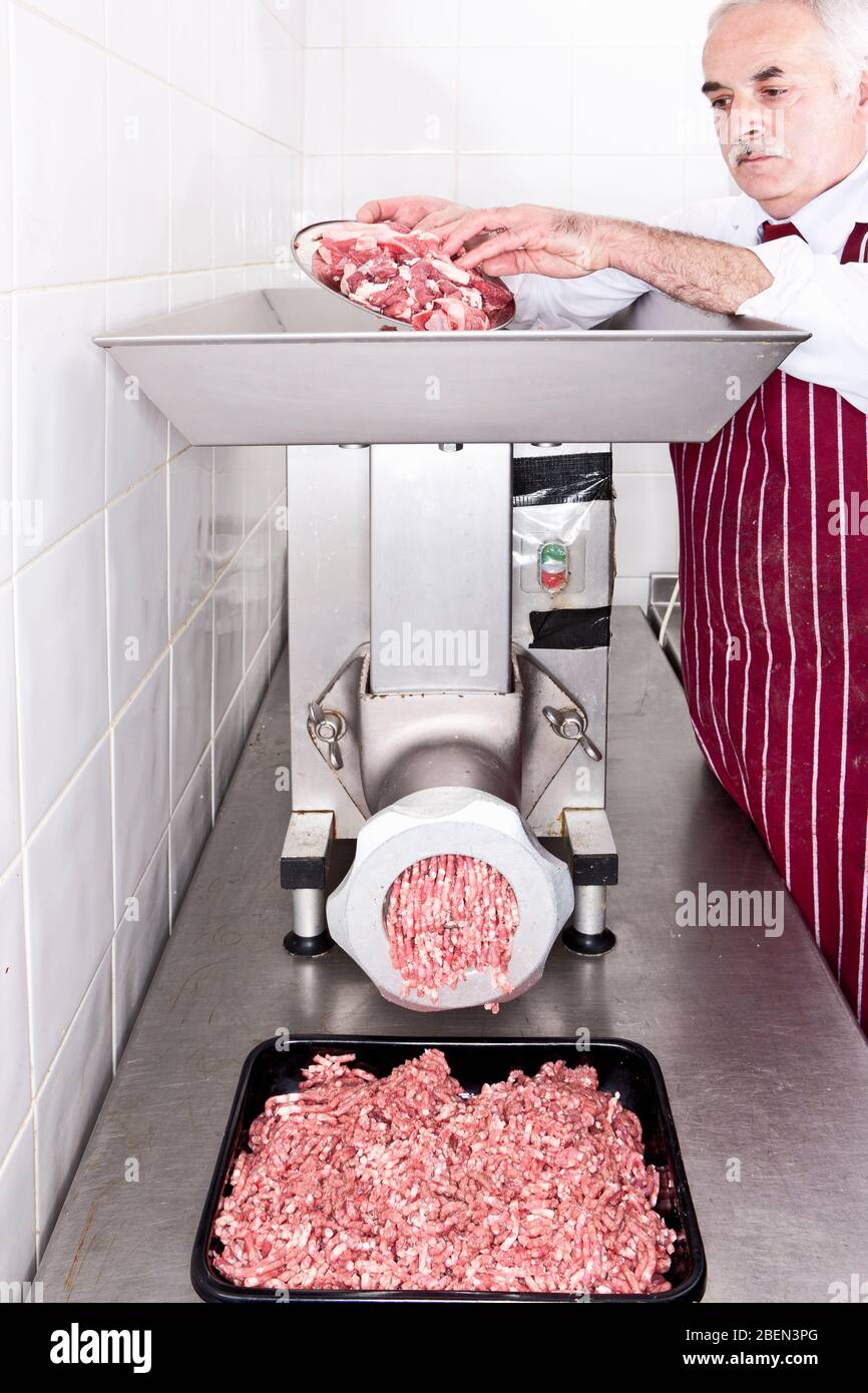 Butcher la macinazione delle carni in negozio Foto Stock