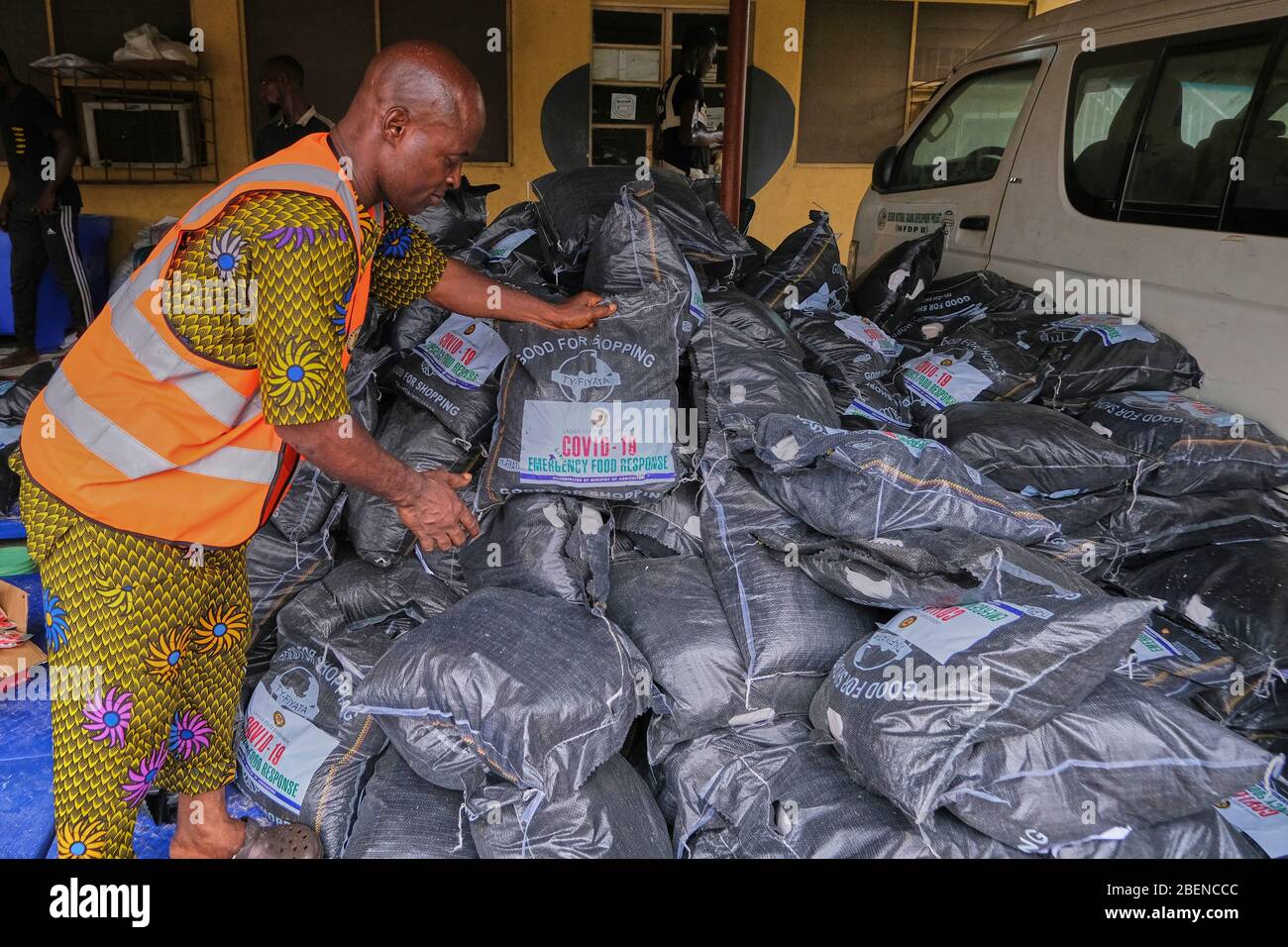 Un lavoratore accatasta alcuni dei pacchetti di emergenza alimentare di Lagos state Covid-19 in un negozio di Lagos, Nigeria. Foto Stock