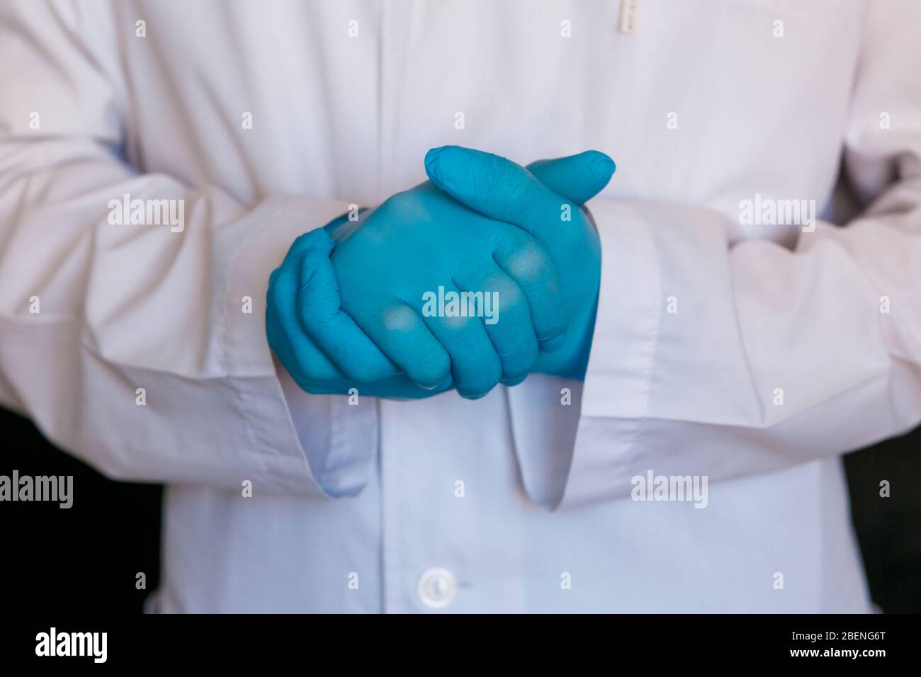 primo piano del medico. Guanti medici del chirurgo su sfondo nero. Foto Stock