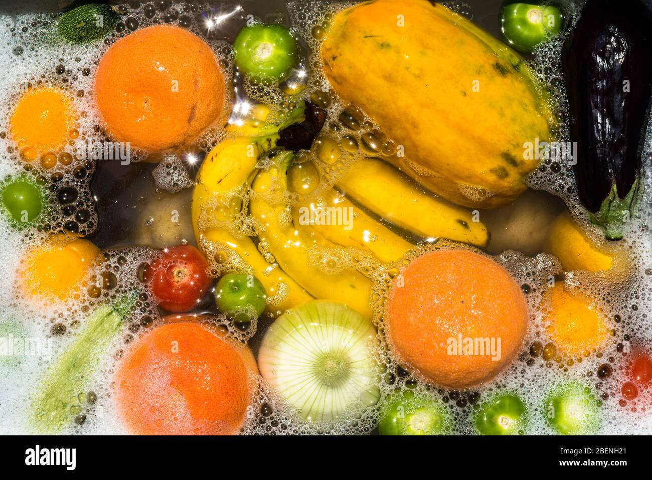 Lavaggio di frutta e verdura in acqua saponata per la disinfezione del coronavirus. Foto Stock