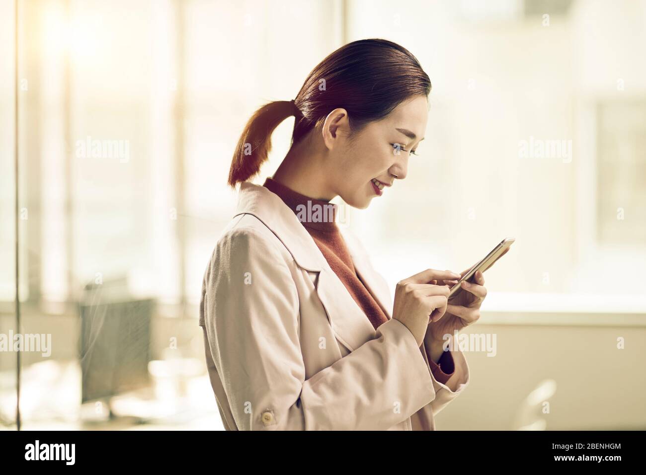 giovane imprenditore asiatico donna business che controlla o invia messaggi di testo utilizzando il telefono cellulare Foto Stock