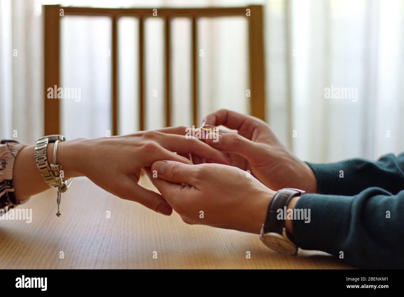 Primo piano di uomo che mette l'anello di aggancio sul dito della donna Foto Stock