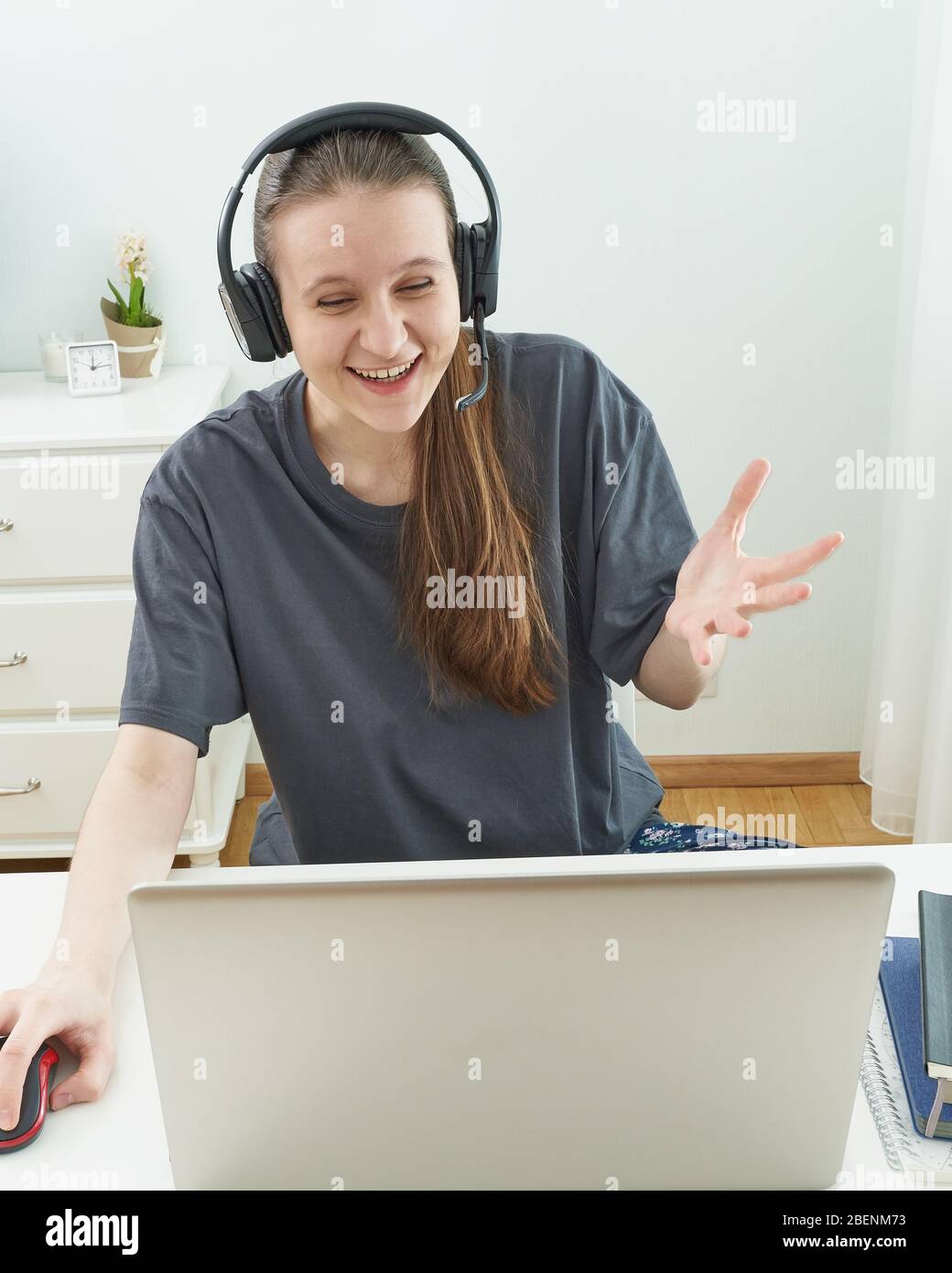 Ragazza con cuffie guarda le informazioni sul computer con sorpresa. Foto Stock