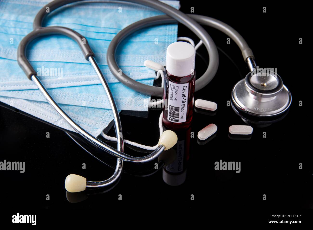 Concetto di Coronavirus o Covid-19 pandemic da usare come sfondo con colore nero e provetta per analisi del sangue, stetoscopio, maschera facciale, medicina per pillole Foto Stock