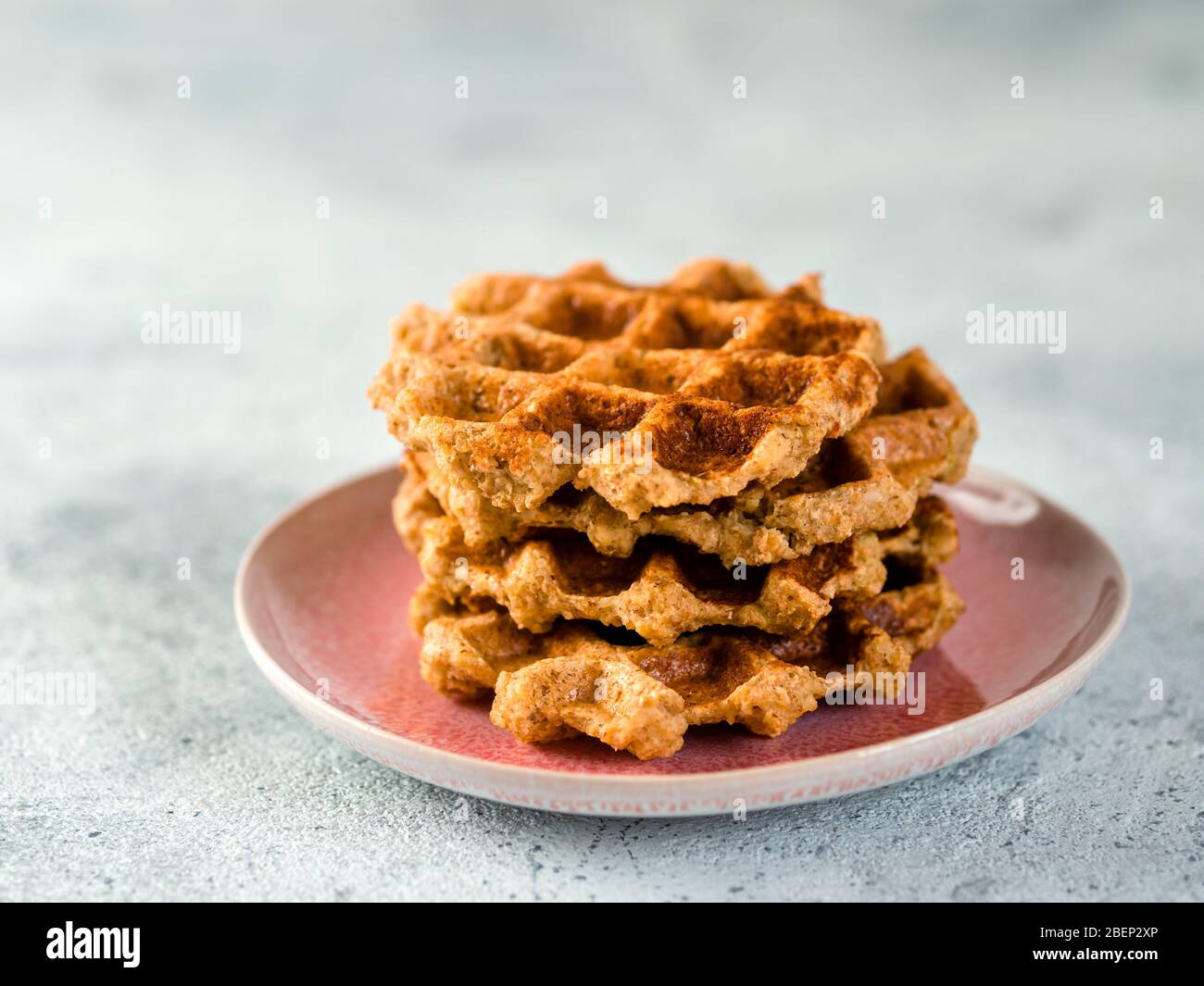 Waffle da avena facili e sani senza glutine con spazio per la copia. Pile di appetitosi waffle fatti in casa con farina d'avena sul piatto su fondo in cemento grigio chiaro Foto Stock