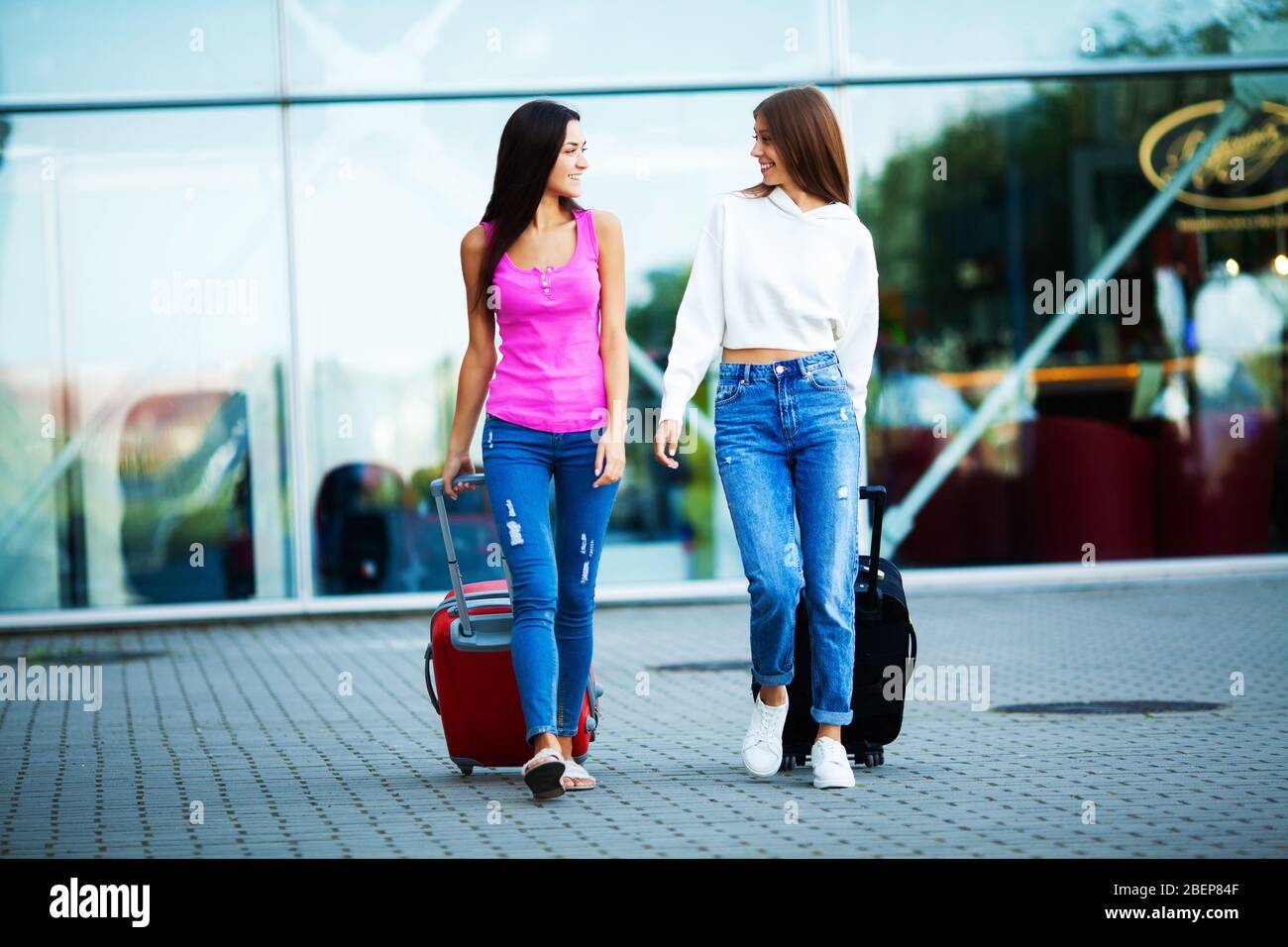 Donne carine che amano viaggiare con valigie vicino all'aeroporto Foto  stock - Alamy