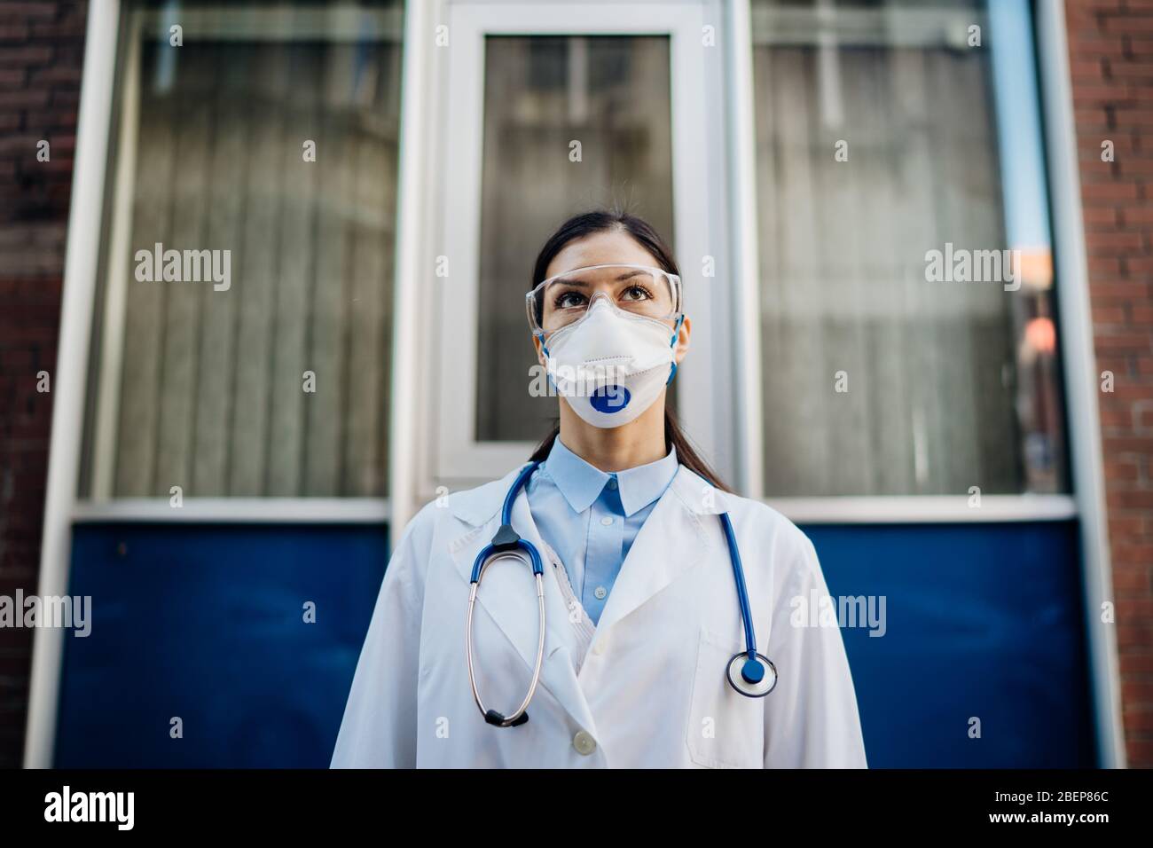 Infettologo di coronavirus di fronte alla struttura ospedaliera di isolamento.esperto di Coronavirus Covid-19.professionista medico con occhiali protettivi e maschera pr Foto Stock