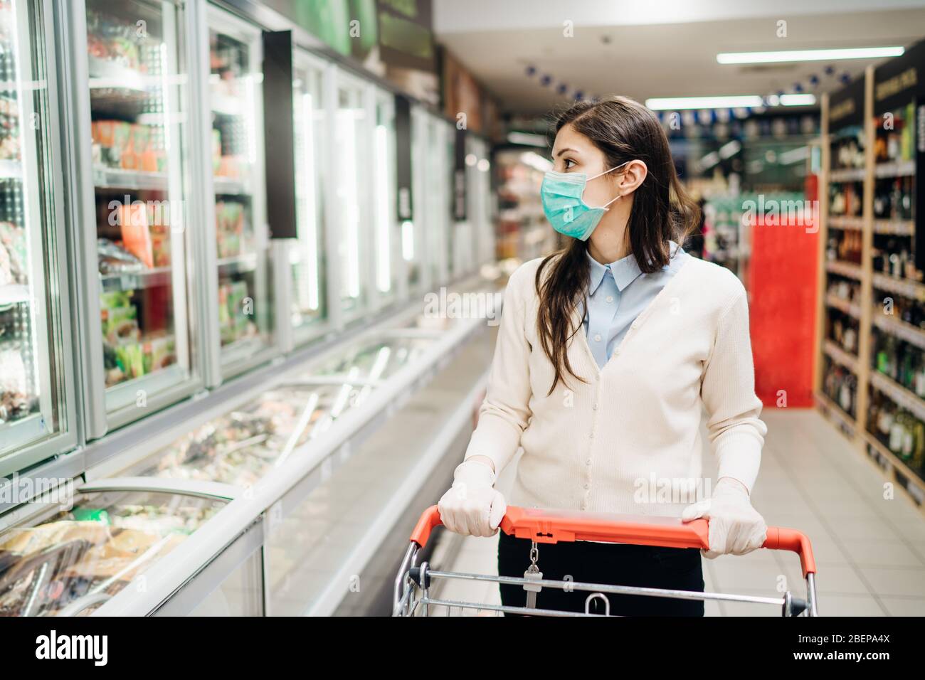 Shopper con maschera sicuro acquisto per alimentari a causa di coronavirus pandemic in negozio di alimentari.COVID-19 shopping.Quarantine Preparation.Panic acquisto e s Foto Stock