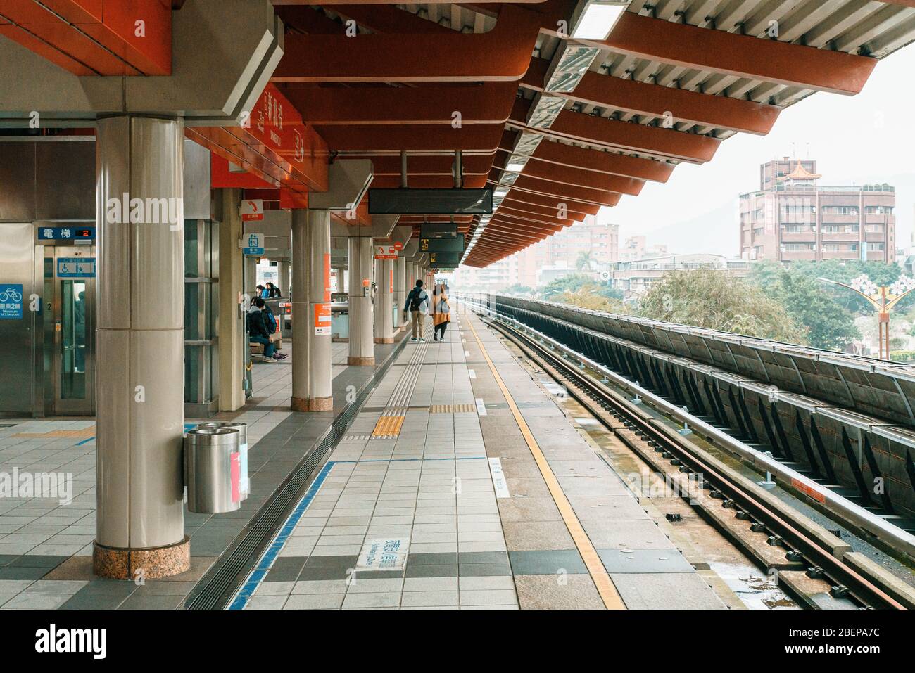 La stazione della metropolitana di Taipei Beitou con persone che aspettano sulla piattaforma per un treno. Mezzi pubblici. Architettura contemporanea con design culturale Foto Stock