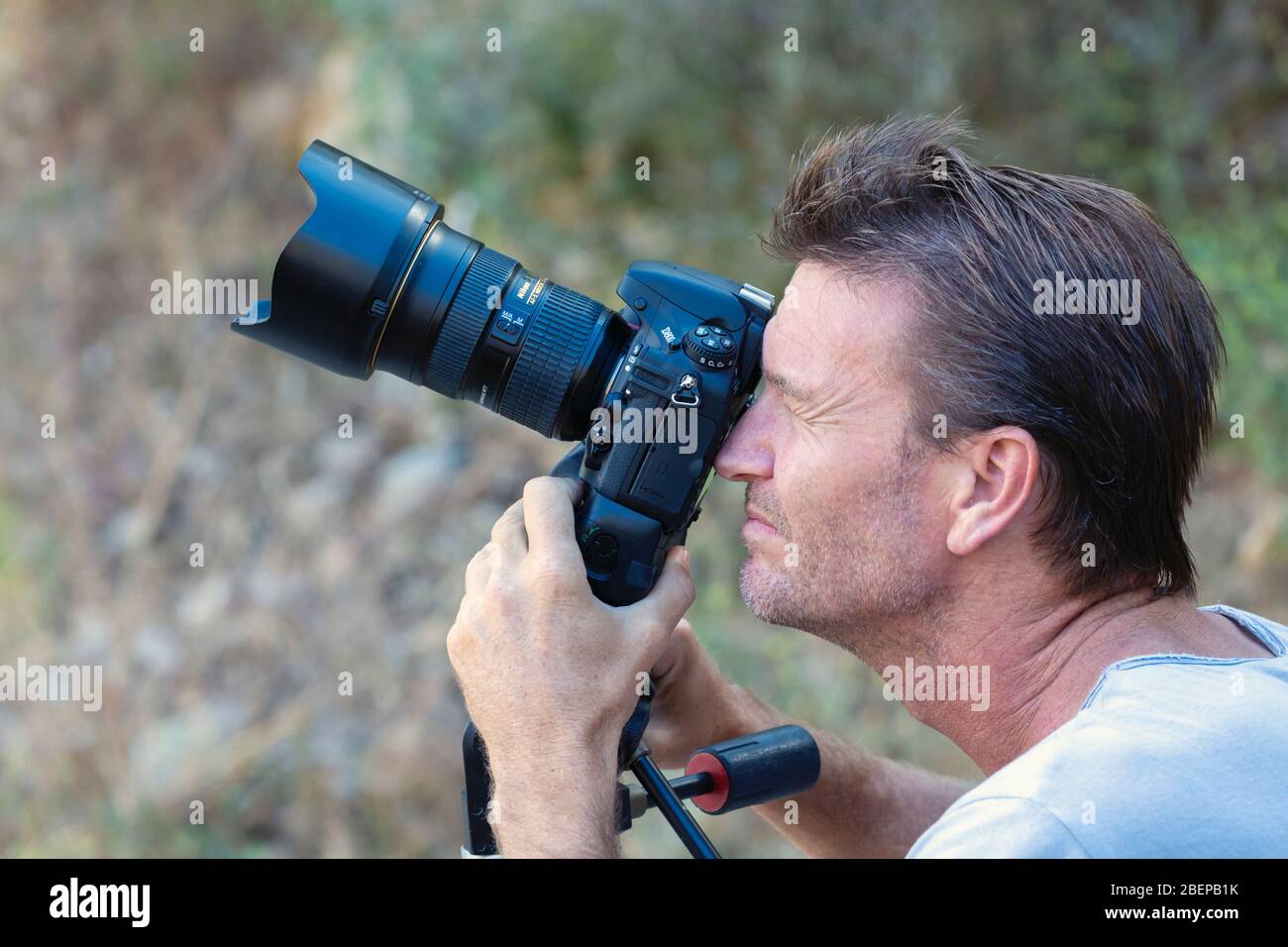 Fotografo che lavora con una fotocamera DSLR. Utilizza una Nikon D800 con obiettivo Nikkor 24 mm F2.8 stabilizzato su una testa a treppiede Mandotto. Foto Stock