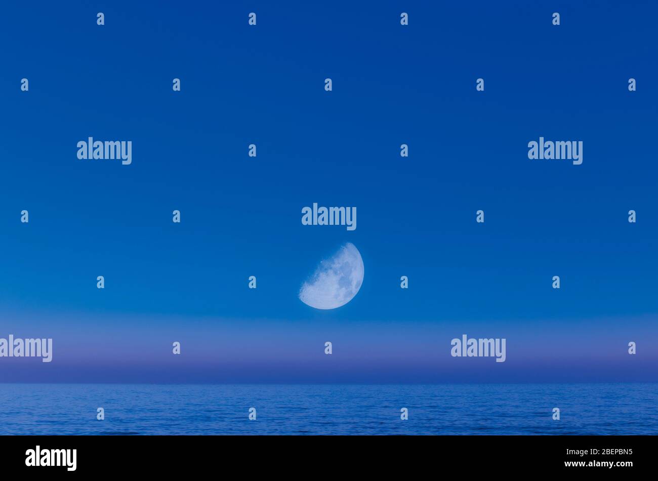 Fotografia composita di mezza luna sul mare. Foto Stock
