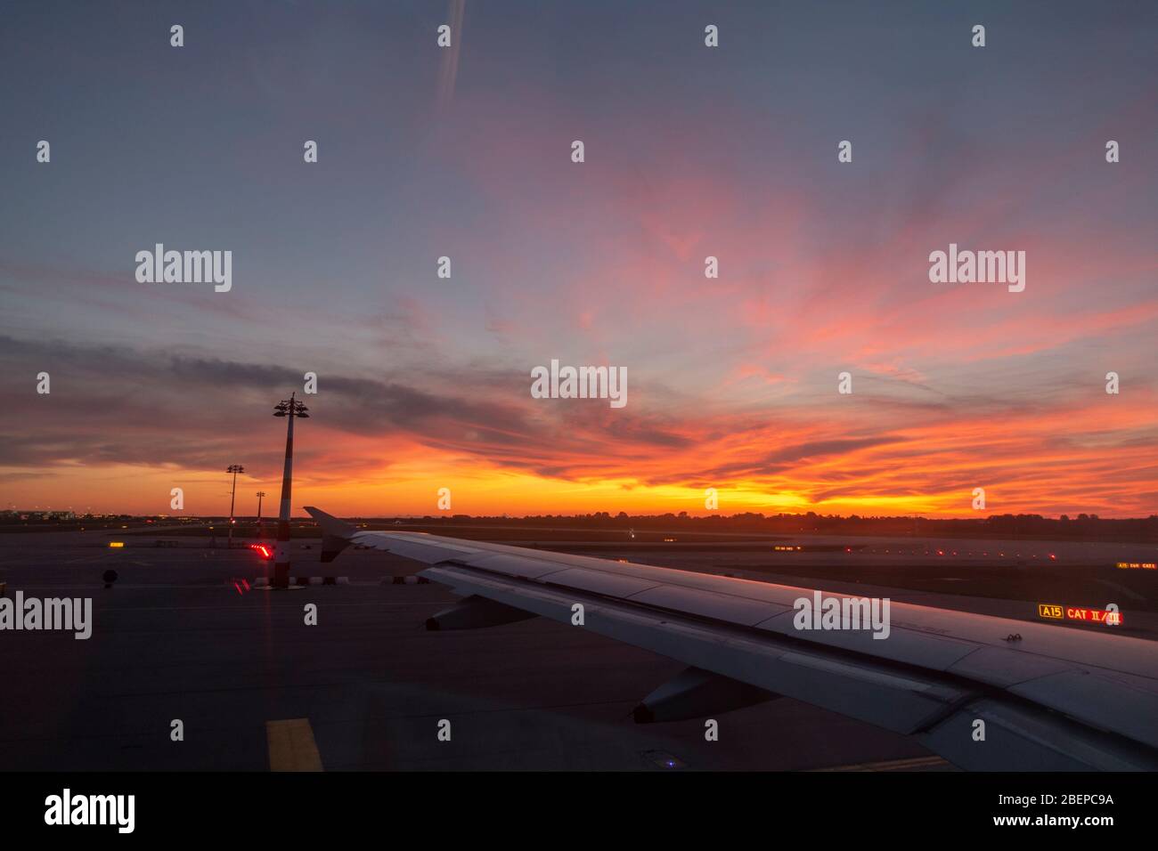 Bella vista al tramonto attraverso un'ala dell'aereo in un aereo in partenza dall'aeroporto di Monaco (Flughafen München), Monaco, Baviera, Germania. Foto Stock