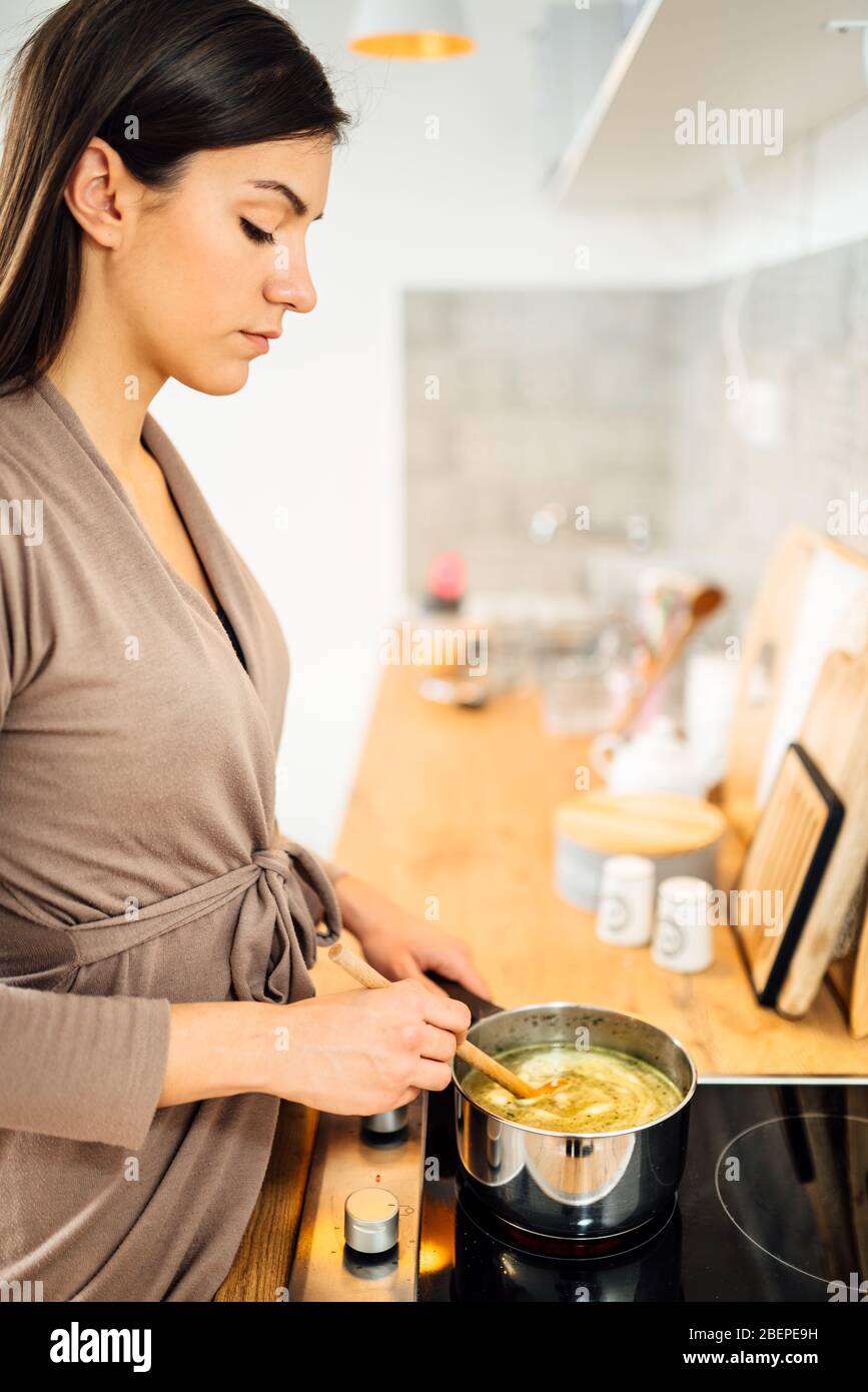 Donna che fa la zuppa di scorta tradizionale fatta in casa.che amplifica il sistema immune.che cucinano brodo.che prepara ricette sane.nutrizionali meals.Healing ricette Foto Stock