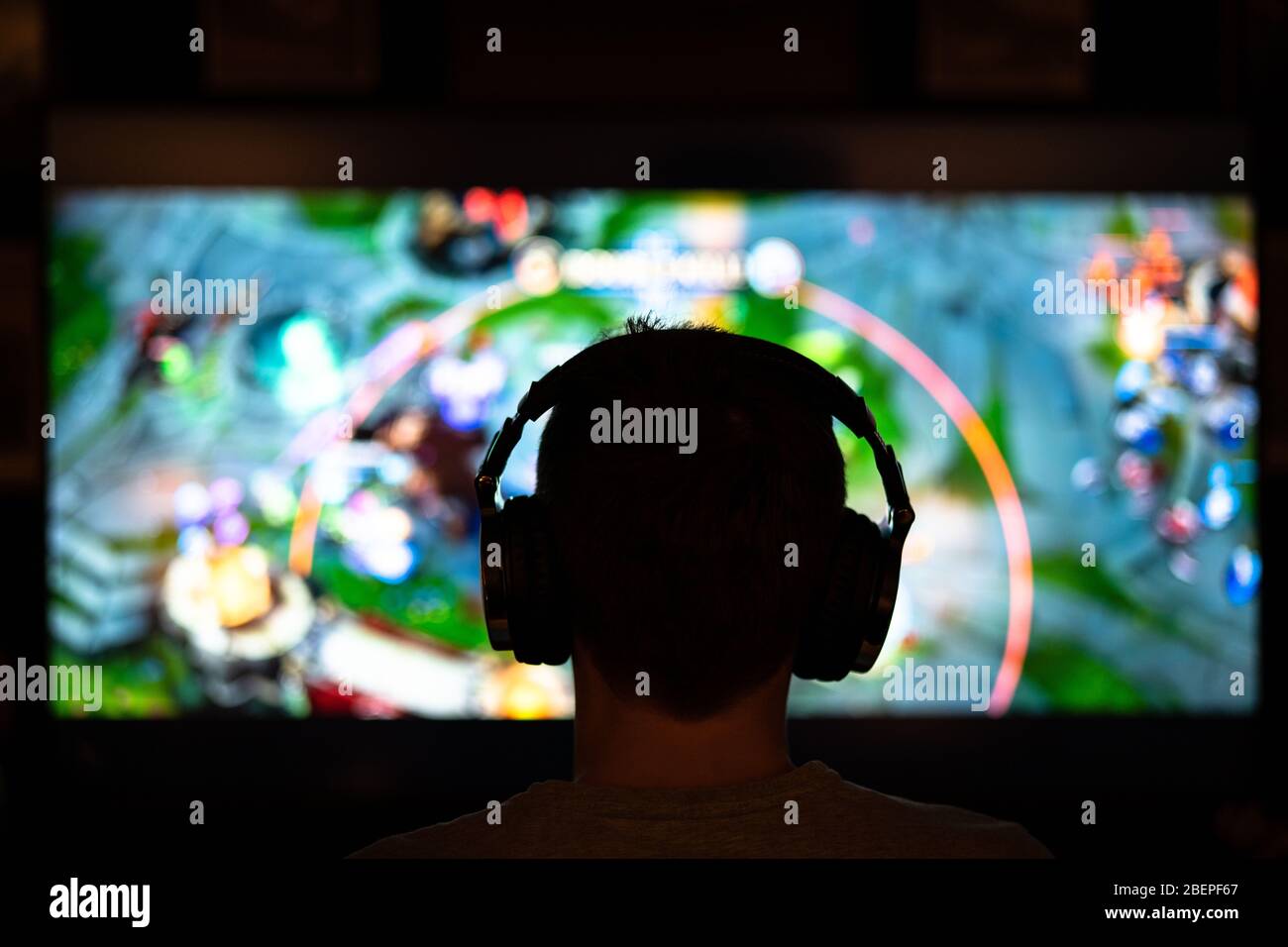 Giocatore adulto con cuffie giocare internet MMORPG cyber strategia online video gioco su computer gaming RIG.Abstract realtà virtuale World.spending ti Foto Stock