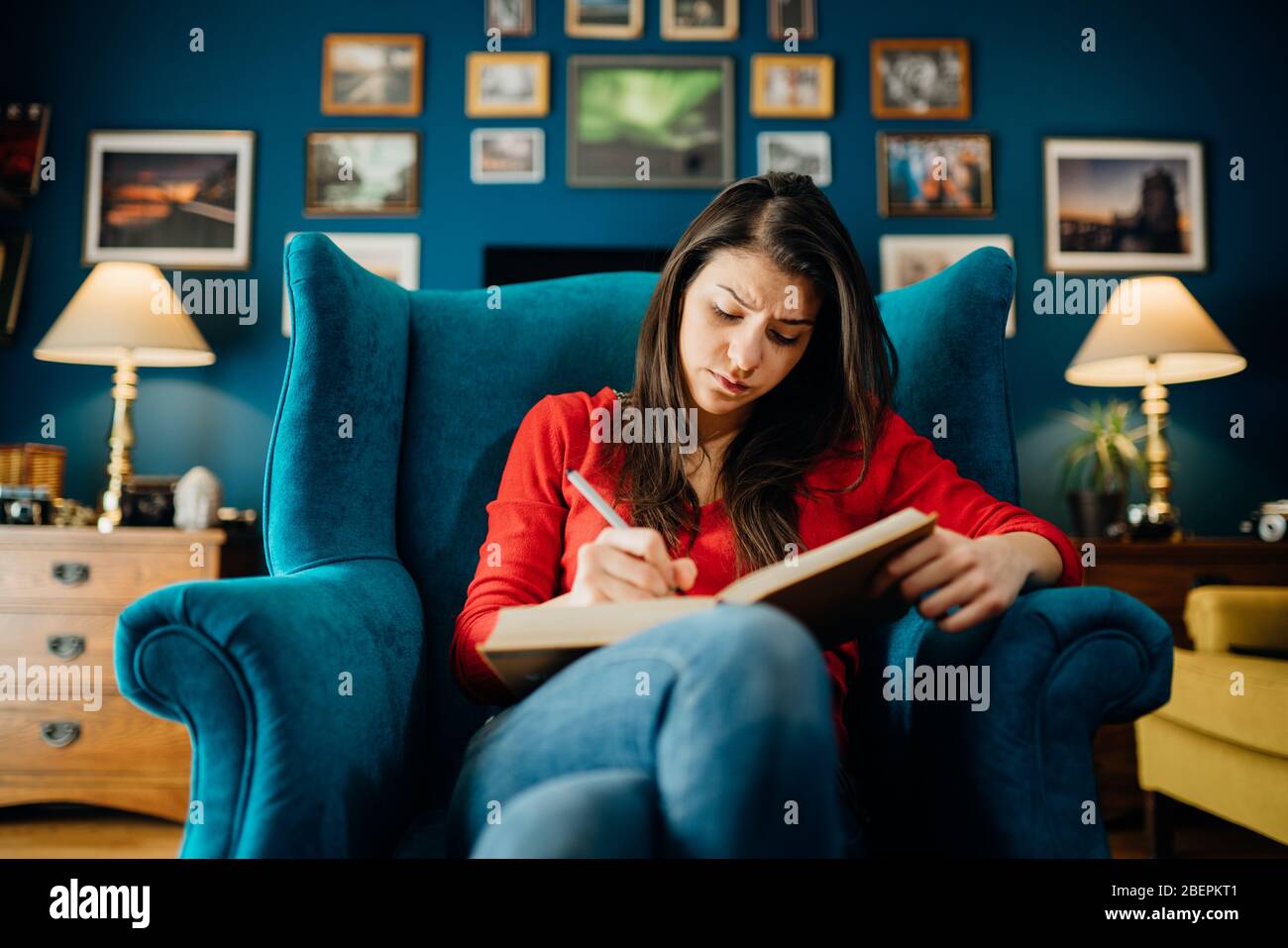Donna che legge/studia una lingua straniera da un libro a home.hitoriosing/underlining difficile letterature.concentration problems.writing poesia crea Foto Stock