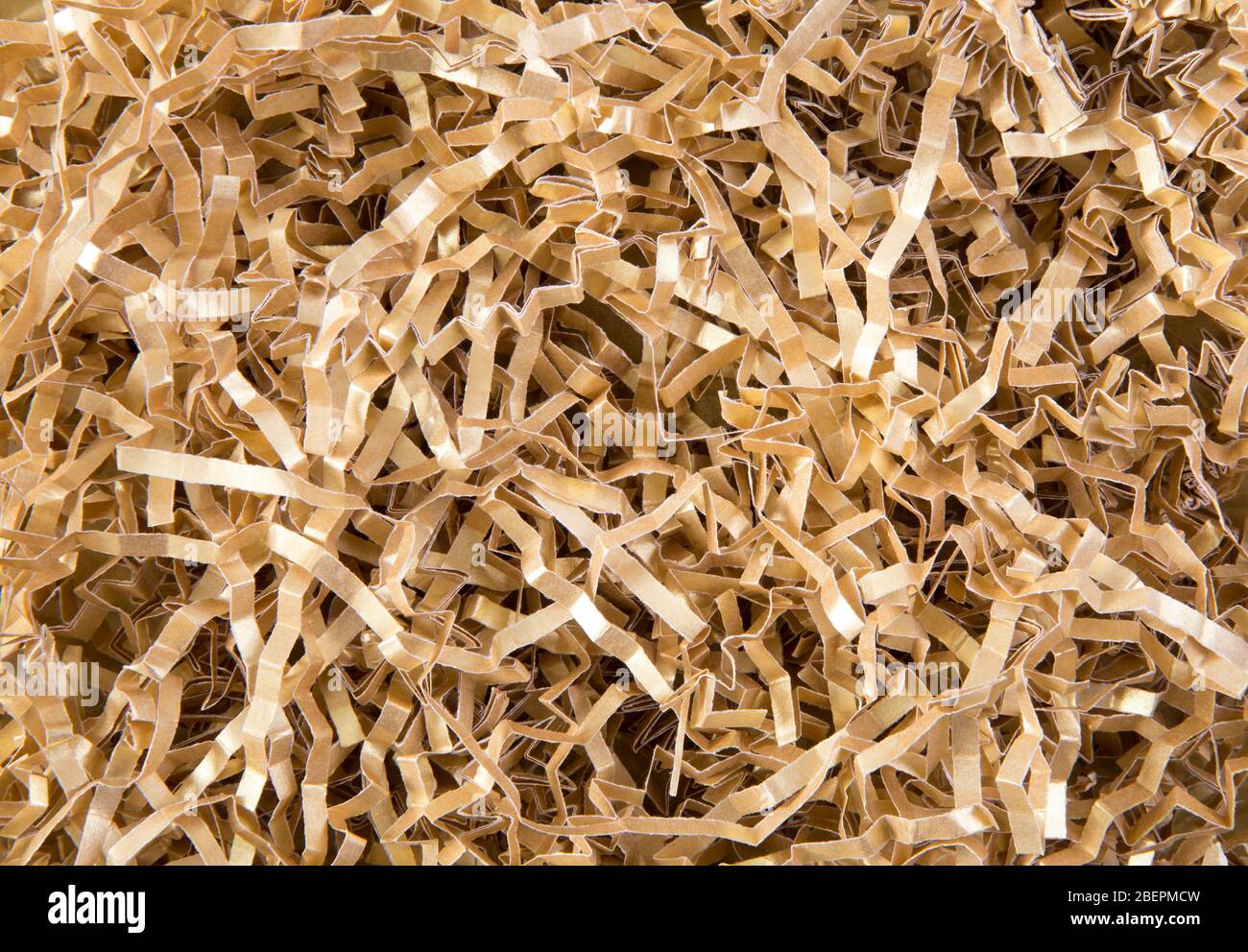 Carta grattugiata color oro - sfondo riempitivo confezione regalo. Foto Stock