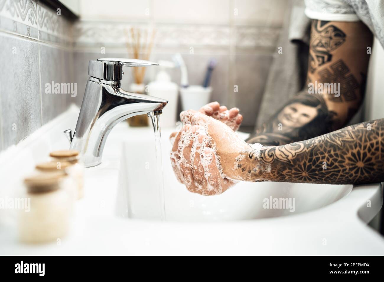 Uomo lavando le mani con sapone e acqua in bagno pulito.protocollo di decontaminazione, igiene delle mani routine.pulizia mani regolarmente.malattia infettiva prev Foto Stock