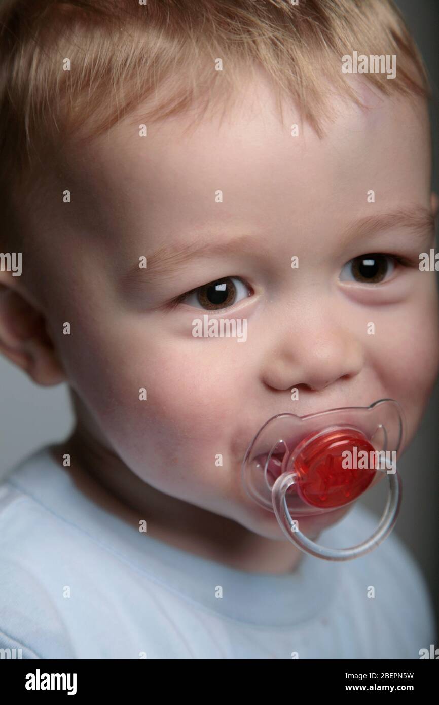 Ritratto di un bambino felice con un manichino in bocca. Foto Stock