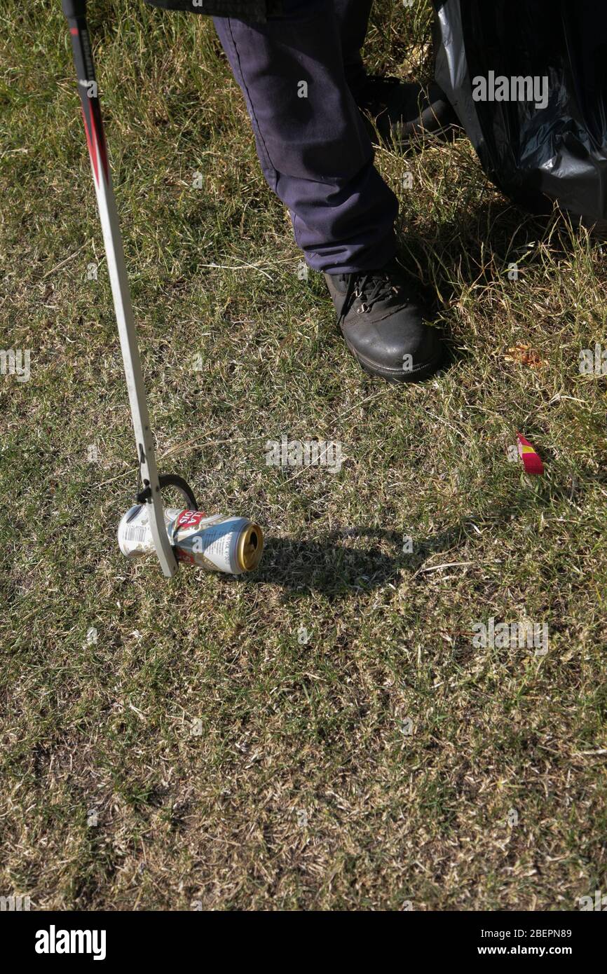 Le lattine vuote di bevanda scartate sono raccolte da un raccoglitore di rifiuti. Foto Stock