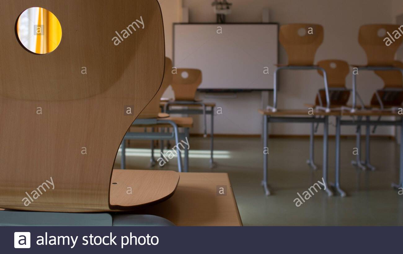 Una sedia di scuola inattiva su una scrivania in un'aula tedesca, mentre le scuole rimangono chiuse a causa del virus Corona. Foto Stock